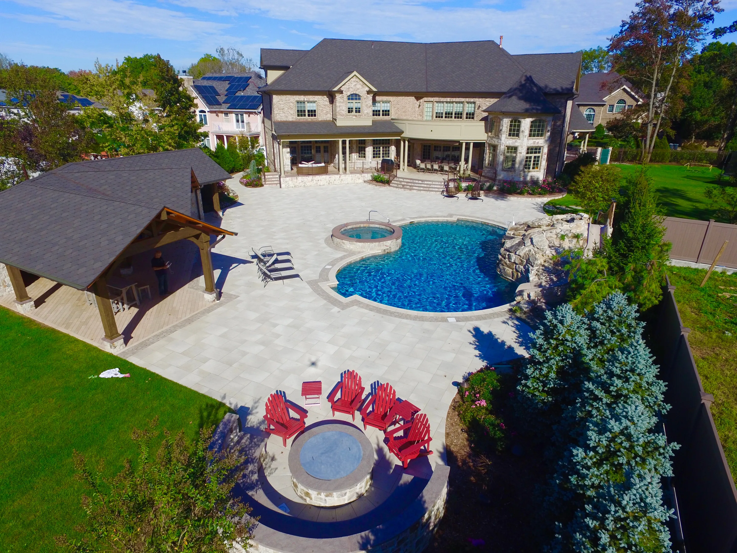 Aerial view of a pool, terrace, and landscaped grounds in New York.