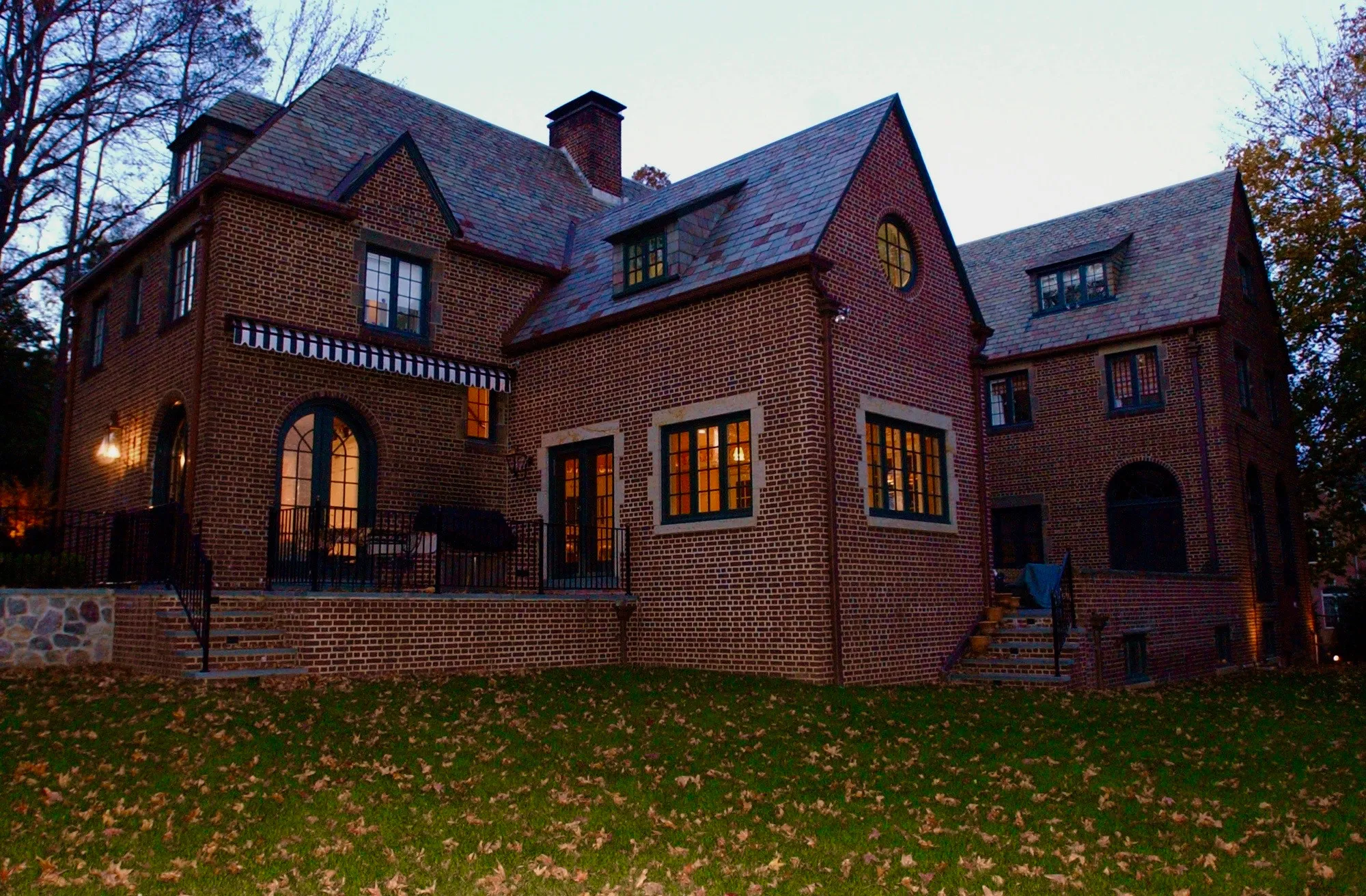 Rear elevation of a brick residence at dusk in New York.