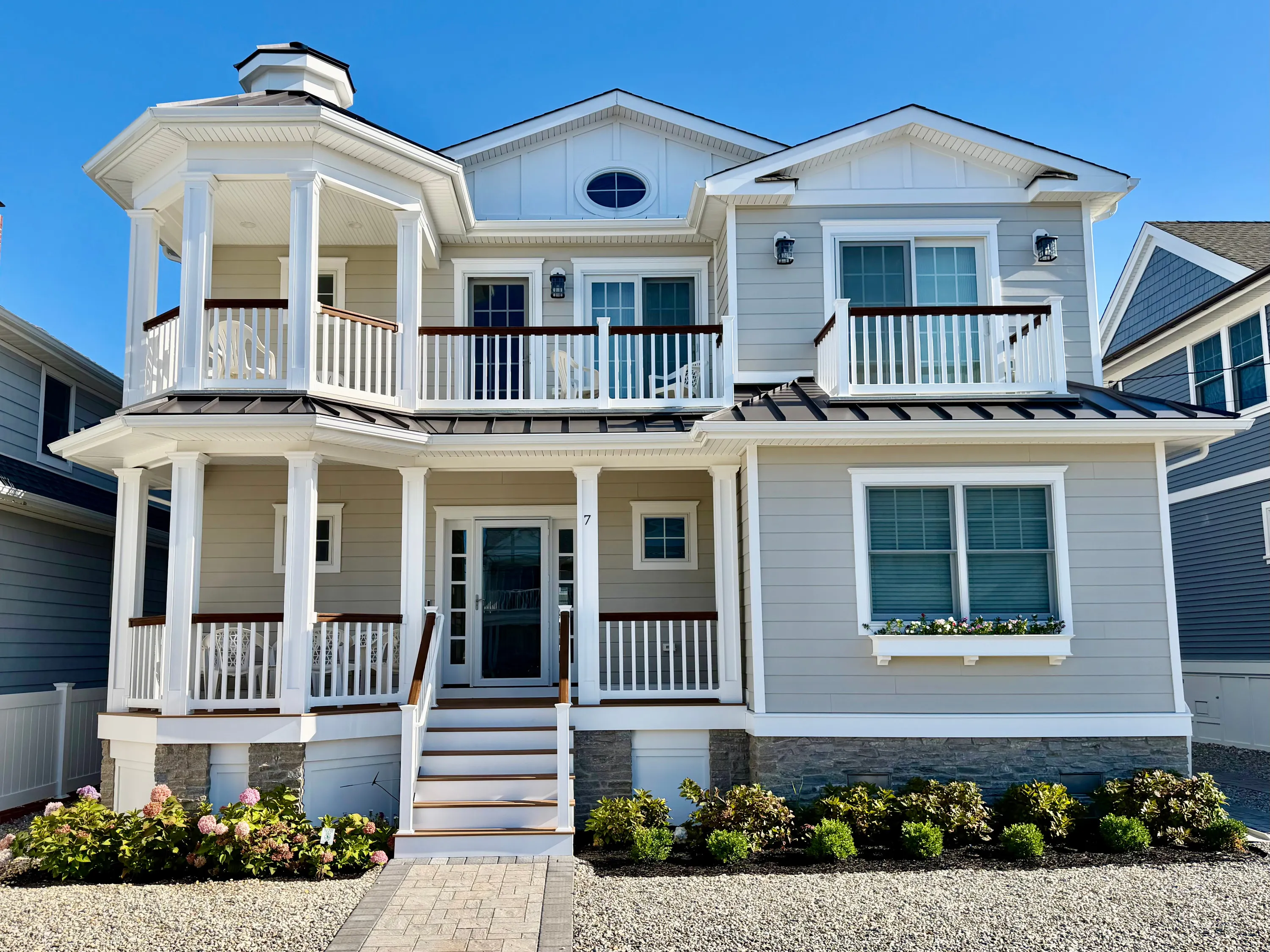 Coastal residence with stacked porches and detailed white trim in New Jersey.