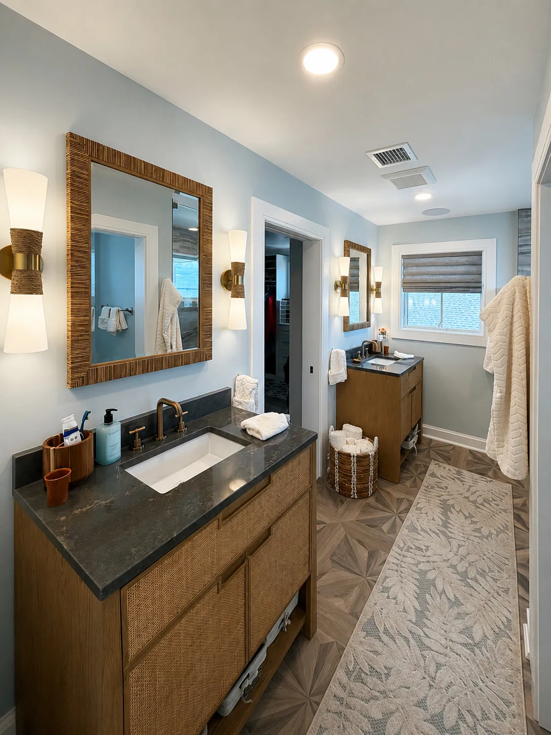 Long bathroom vanity with dark counters and wood cabinetry.