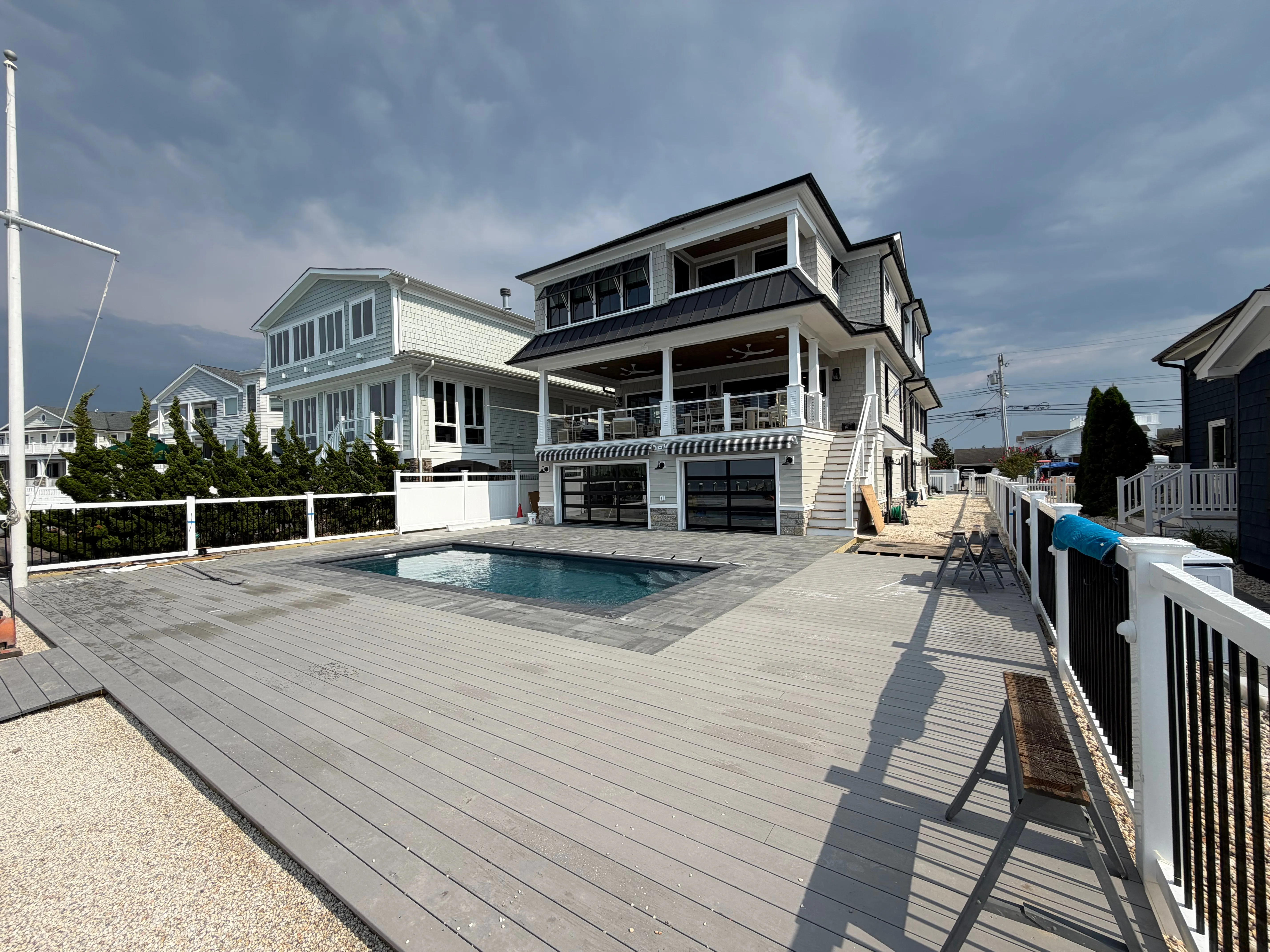 Rear view of the coastal residence with a pool and waterfront deck.