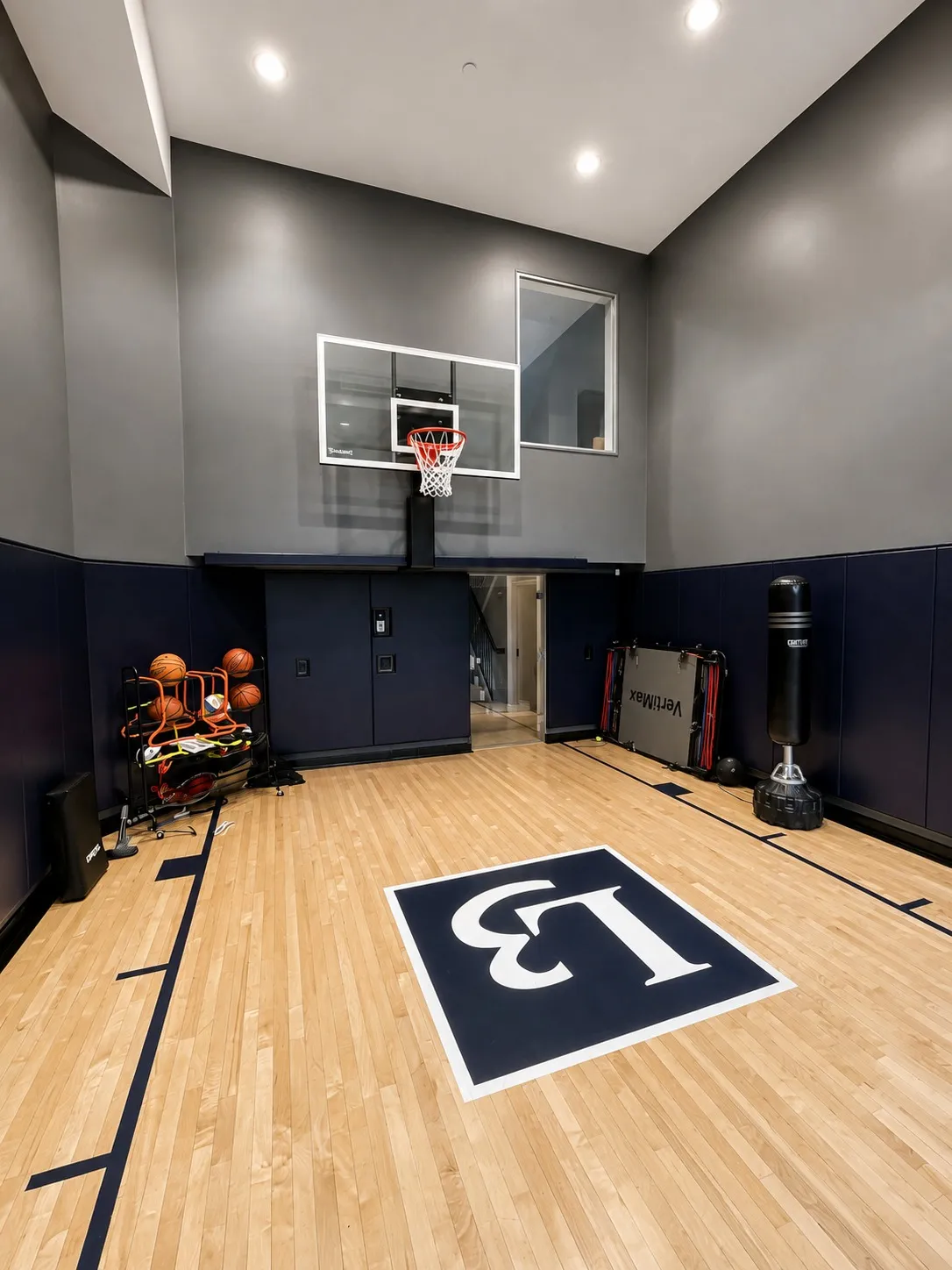 Indoor basketball court with a high dark ceiling and wall-mounted hoop.