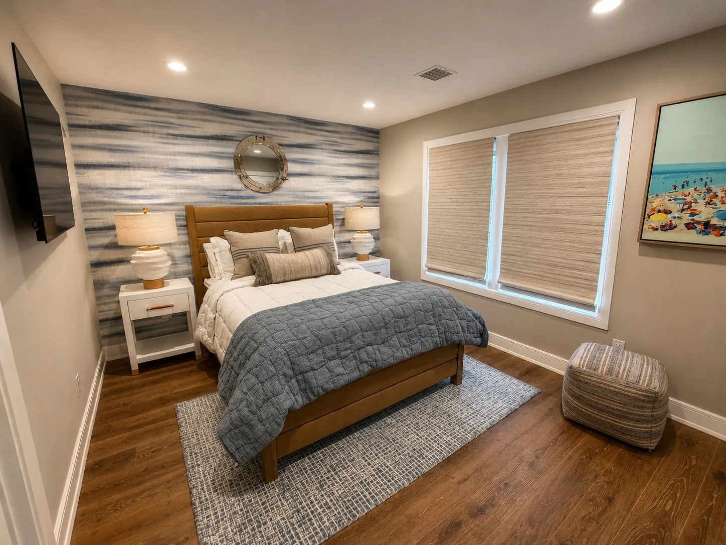 Bedroom with a blue textured feature wall and wood flooring.