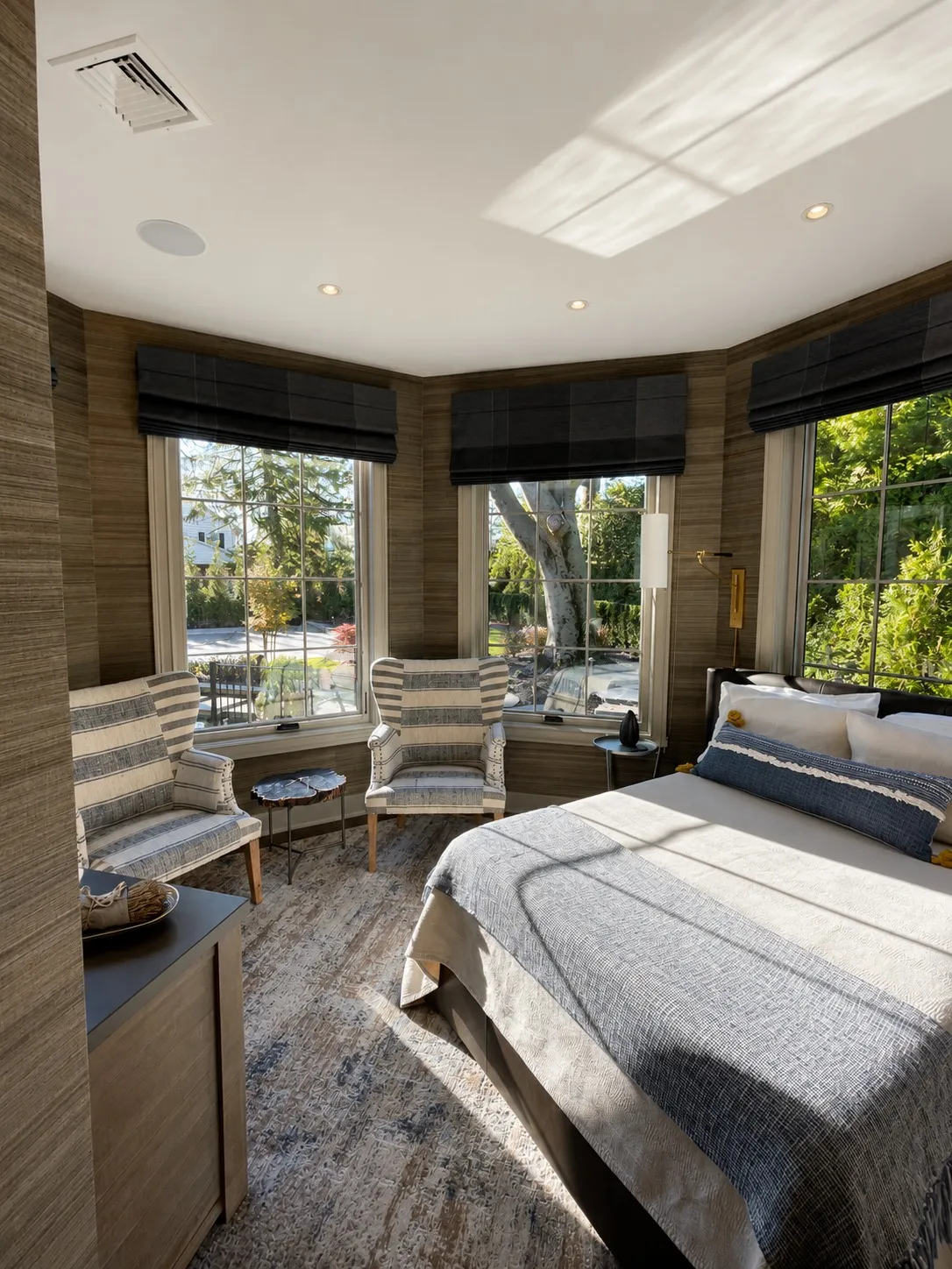Bedroom sitting area with curved windows and integrated wood details.