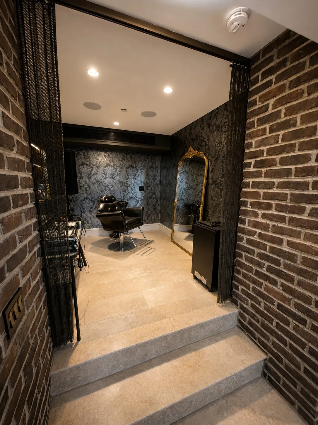 Brick-lined interior passage opening into a stone-finished room.