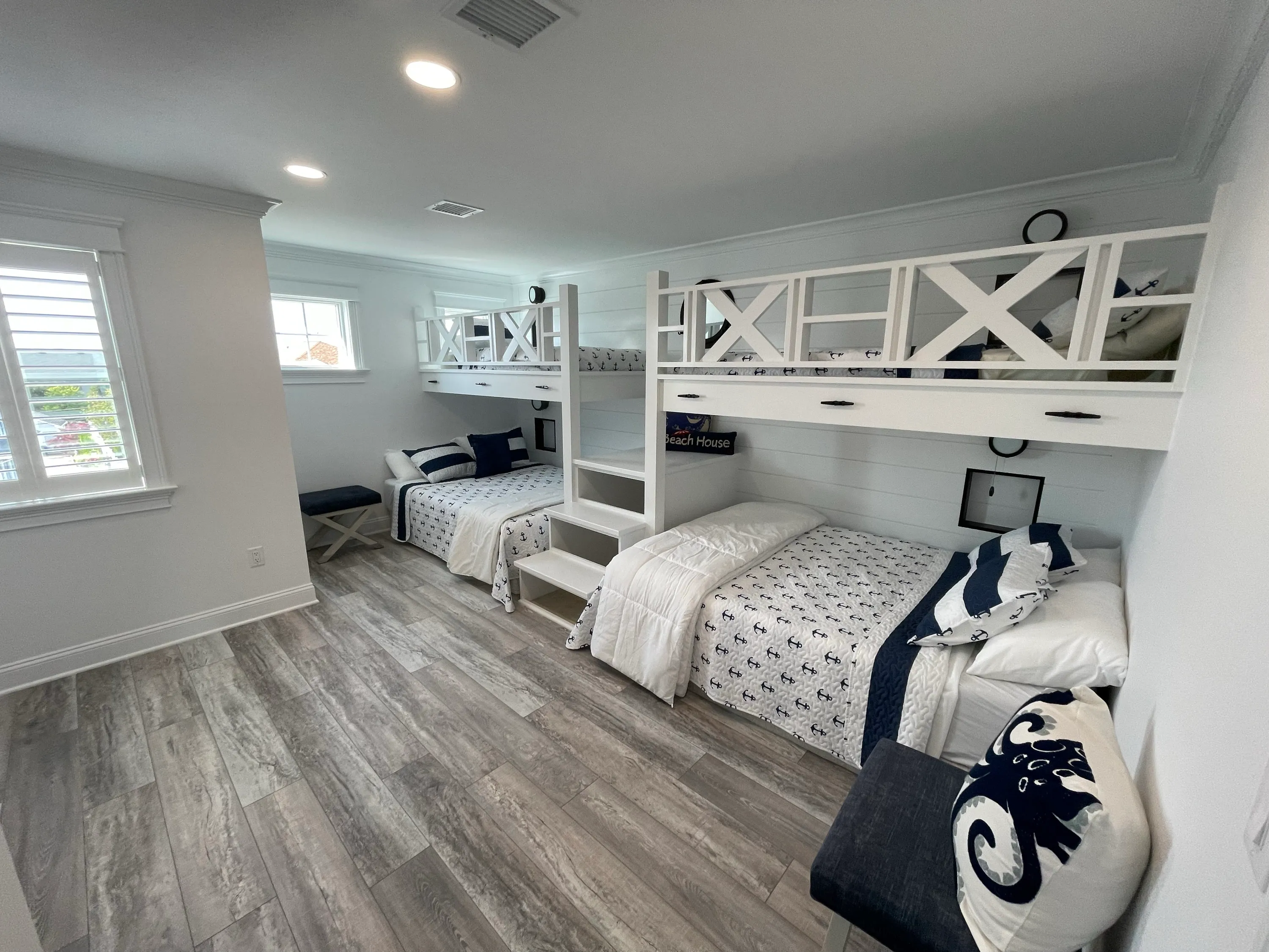 Custom bunk room with integrated beds, shelving, and nautical details.