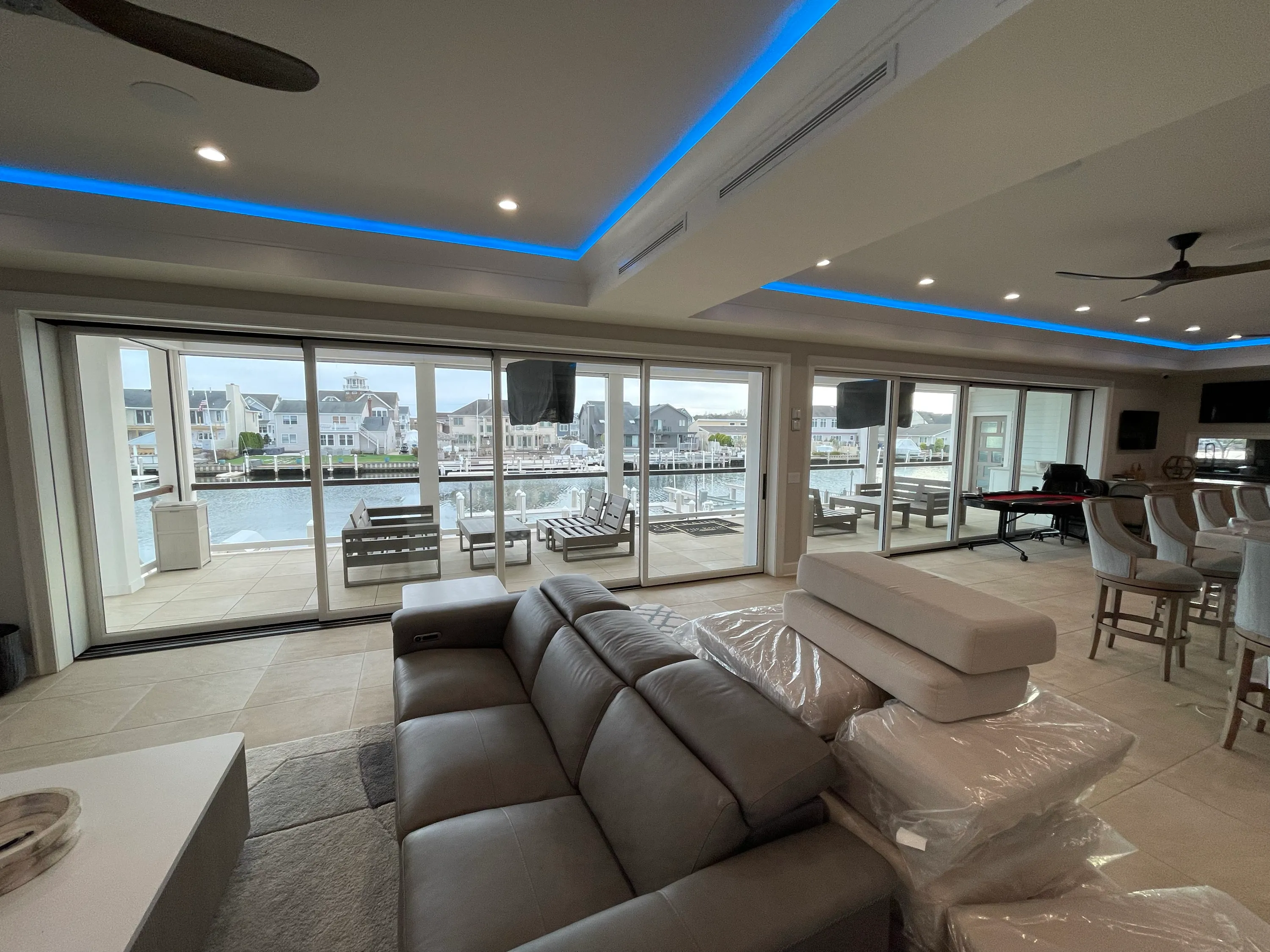 Waterfront living room with broad glass doors and a recessed ceiling detail.