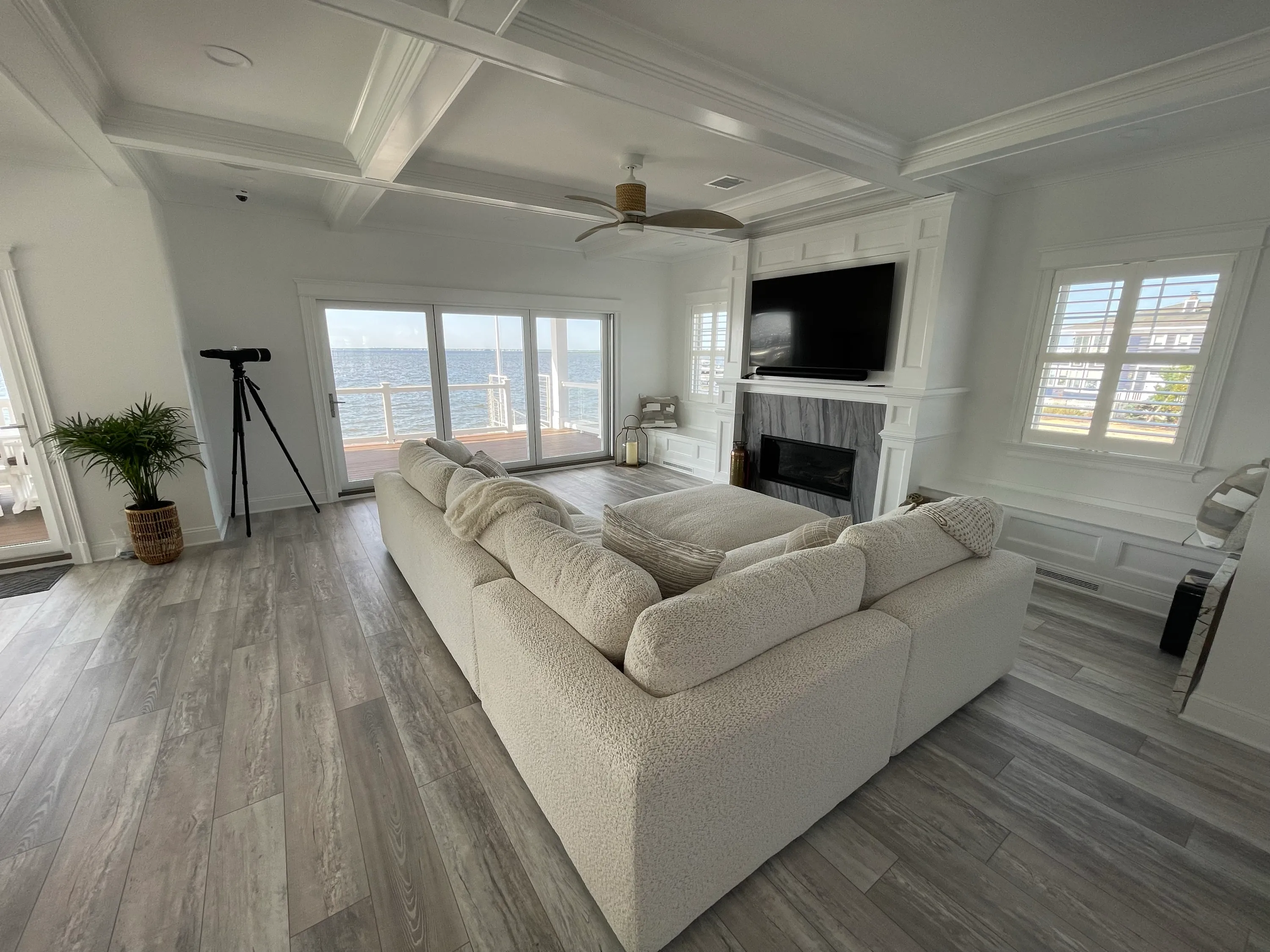 Waterfront living room with built-in millwork, a fireplace, and broad windows.