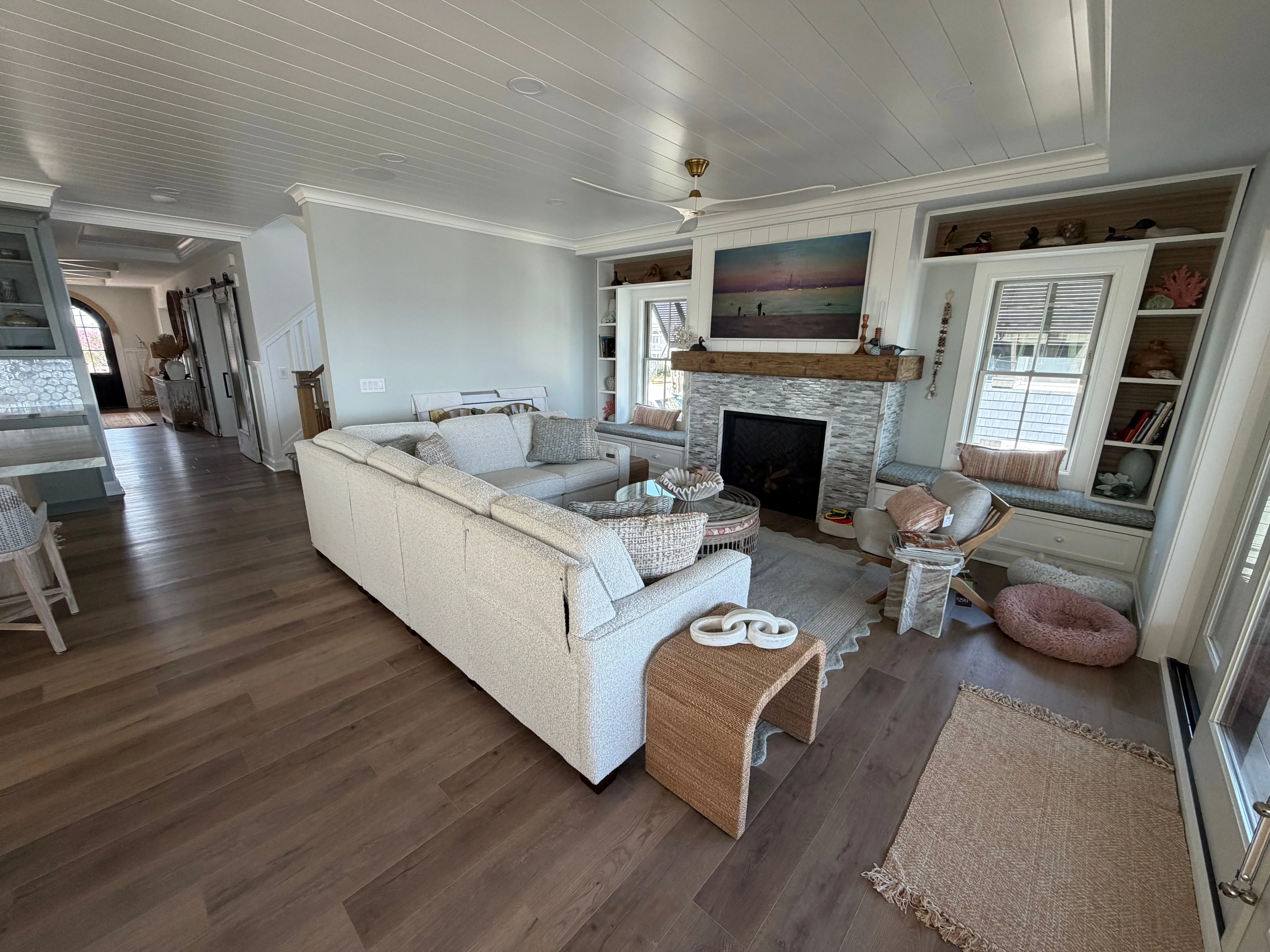 Living room with built-in shelving, a fireplace, and wide waterfront windows.