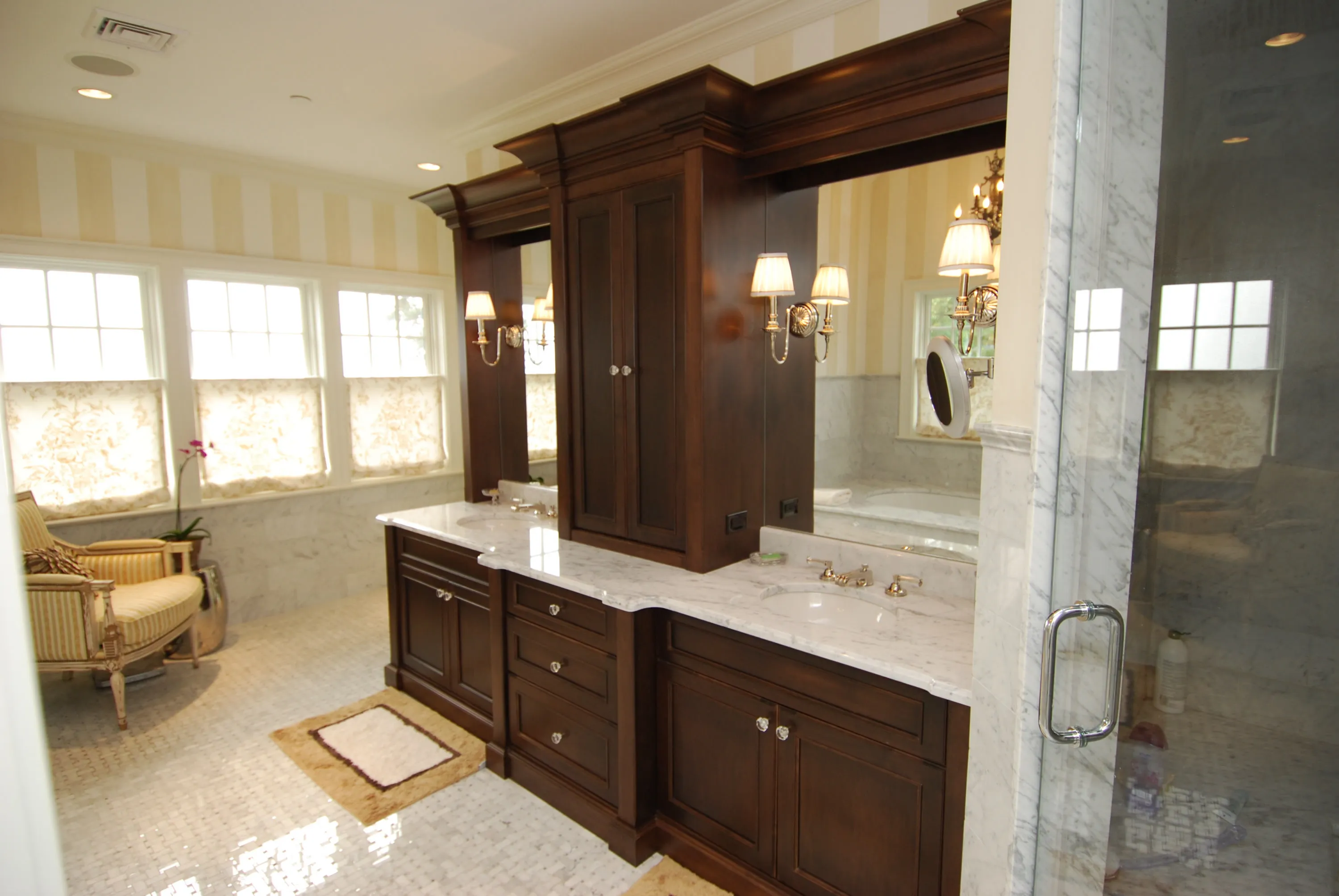 Primary bathroom with dark wood vanities and a glass shower enclosure.