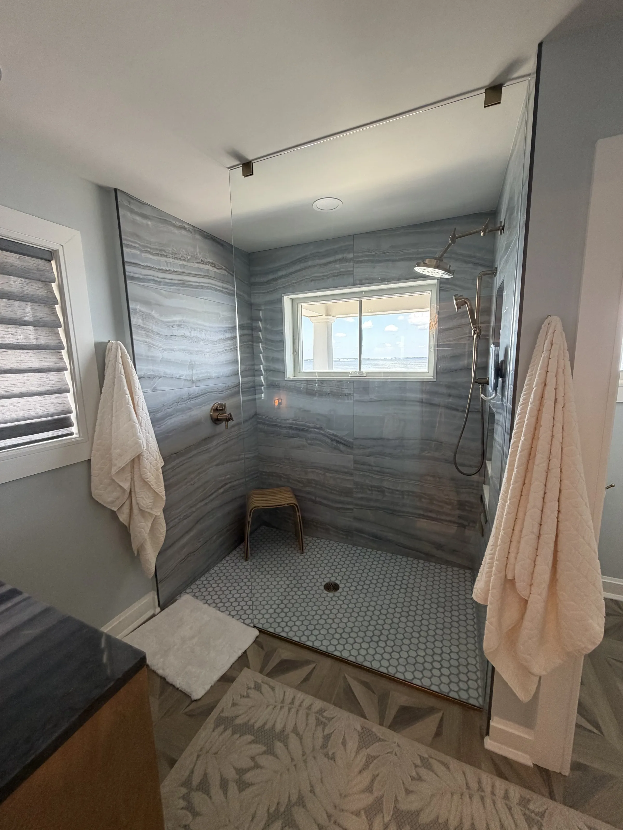 Walk-in shower with gray wall tile and a glass enclosure.