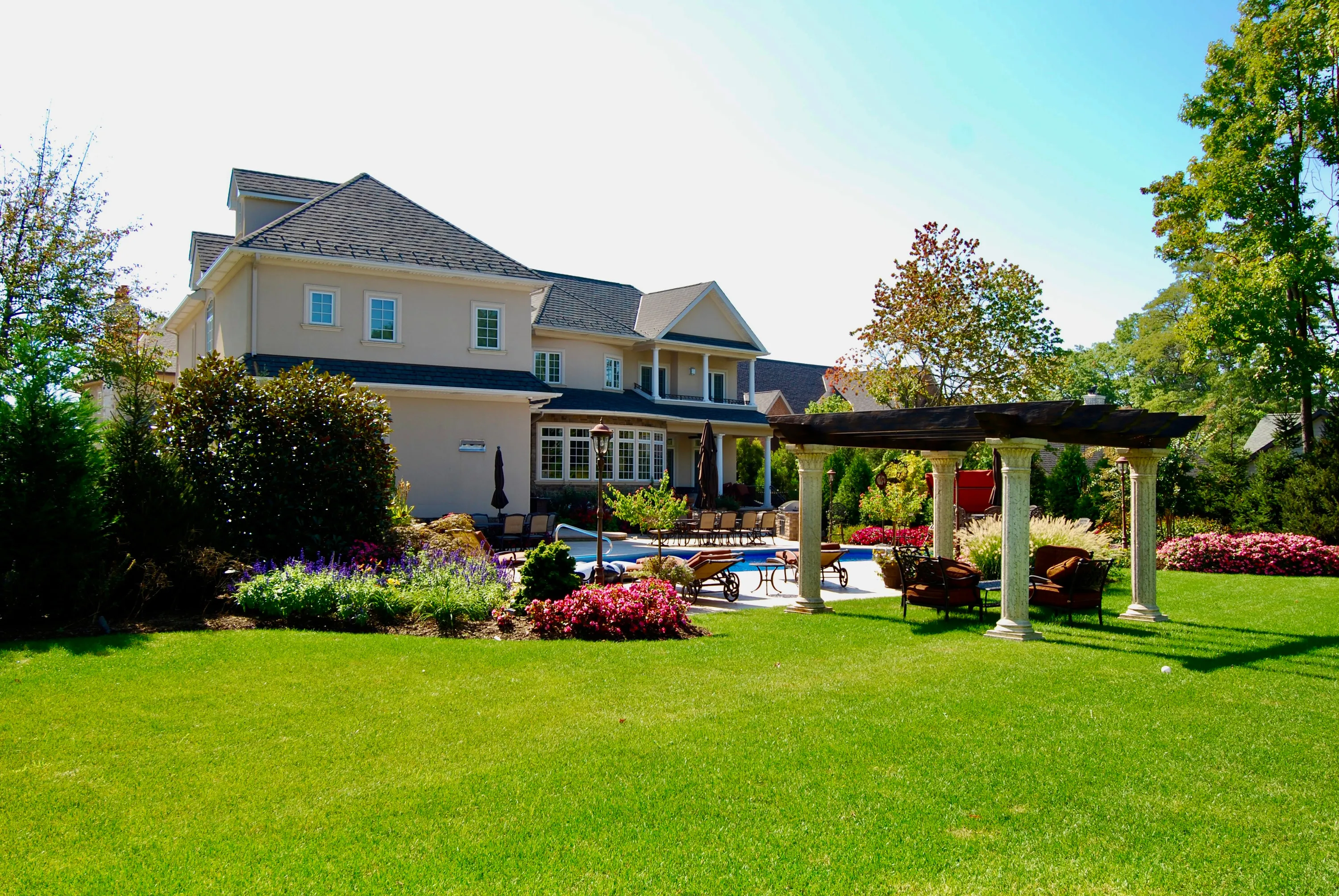 Landscaped rear lawn, terrace, and residence in New York.