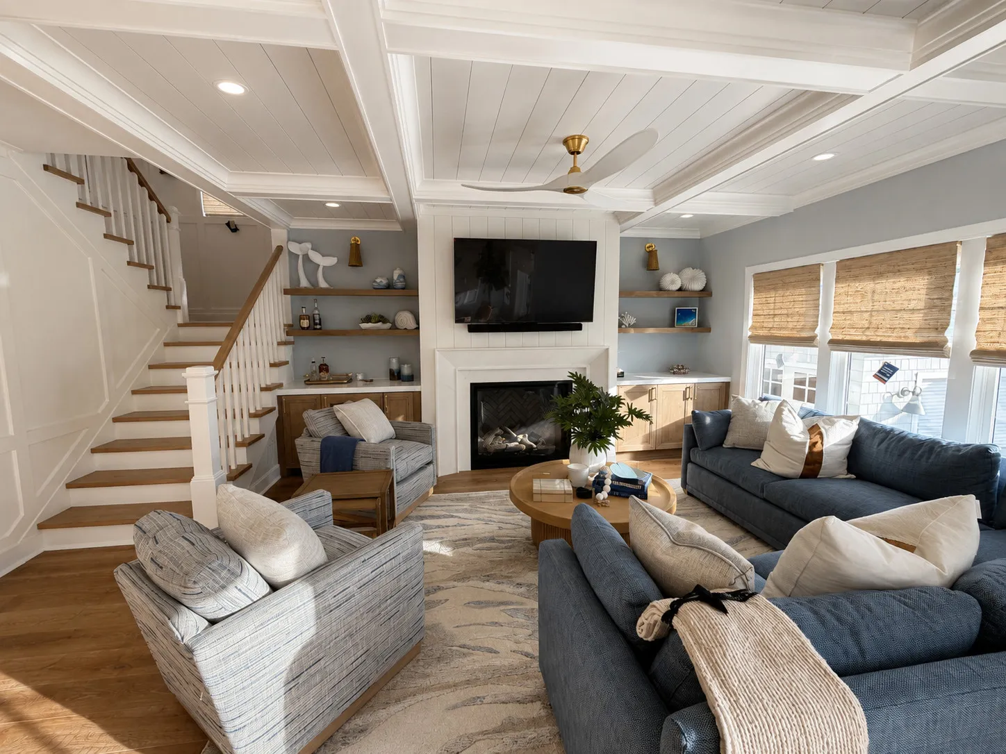 Living room with a fireplace, built-in shelves, and an open stair.