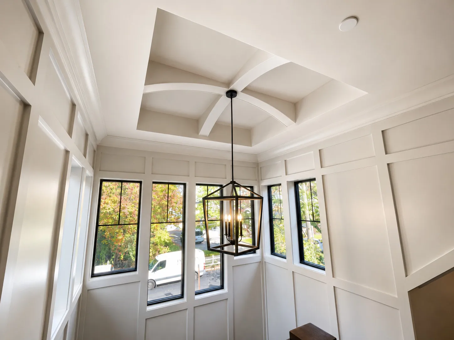 Paneled ceiling and detailed interior millwork beside garden doors.