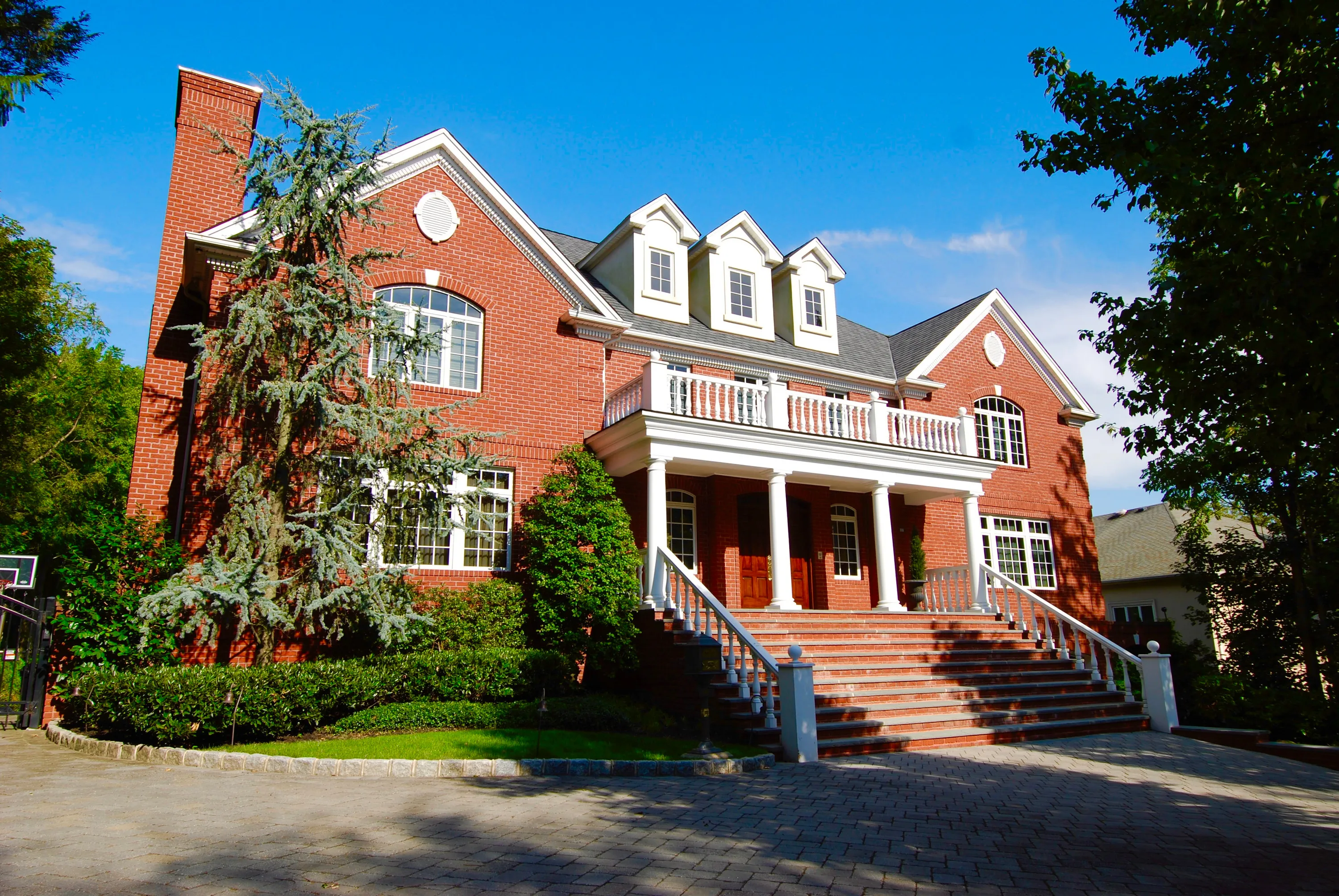 Red brick residence with detailed masonry and a raised entry in New York.