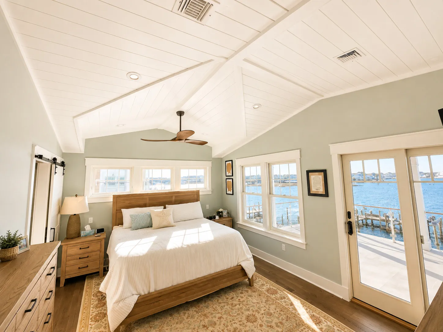 Waterfront bedroom with a vaulted ceiling and direct deck access.