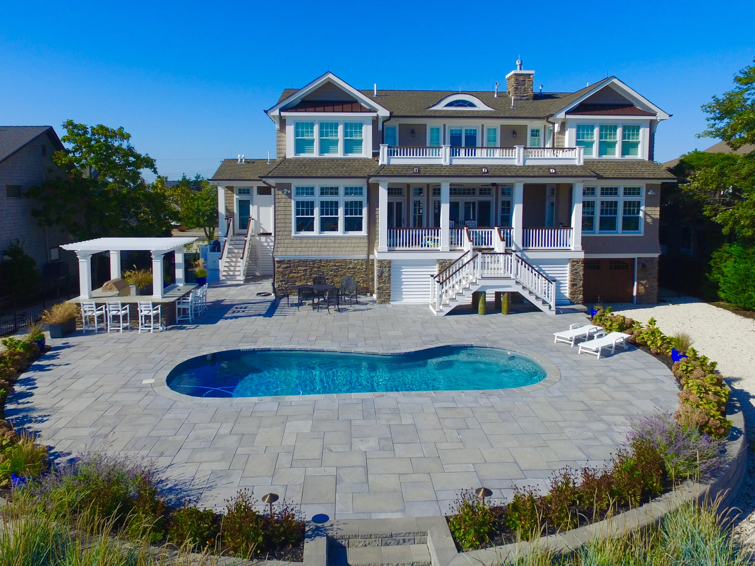 Aerial rear view of a waterfront residence and pool in New Jersey.