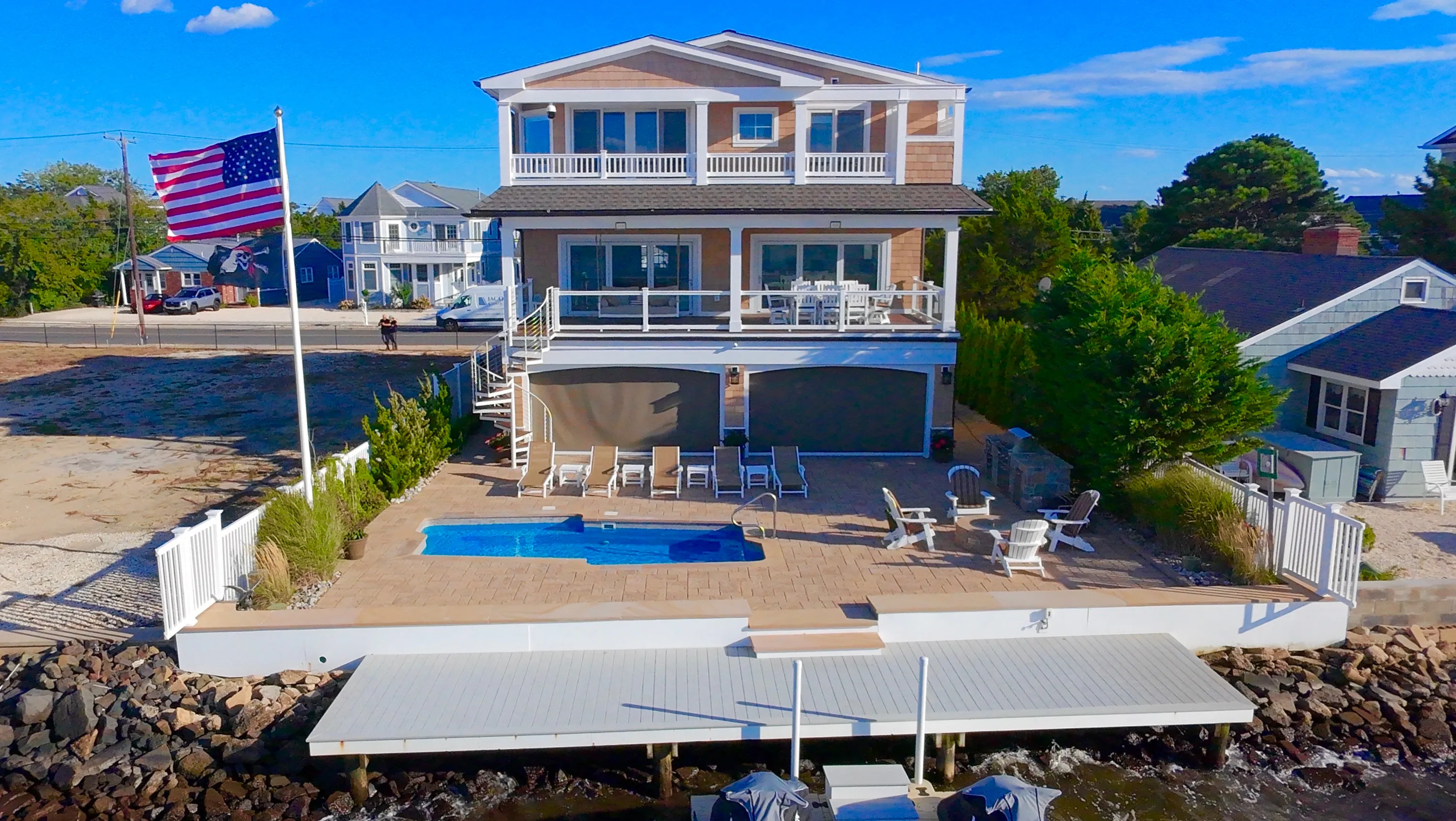 Waterfront residence, pool, and dock viewed from the bay in New Jersey.